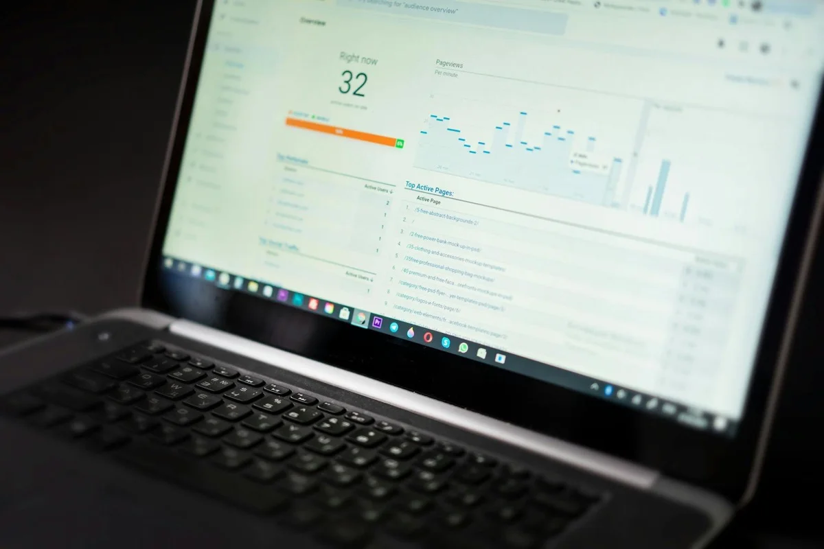 Laptop mostra dashboard analytics con grafici real-time, integrazione AI su dati gestionale
