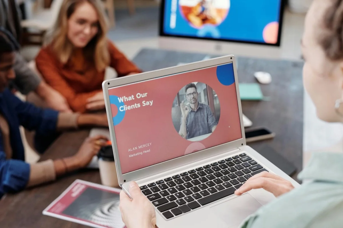 Team che discute progetto con laptop durante una riunione di lavoro