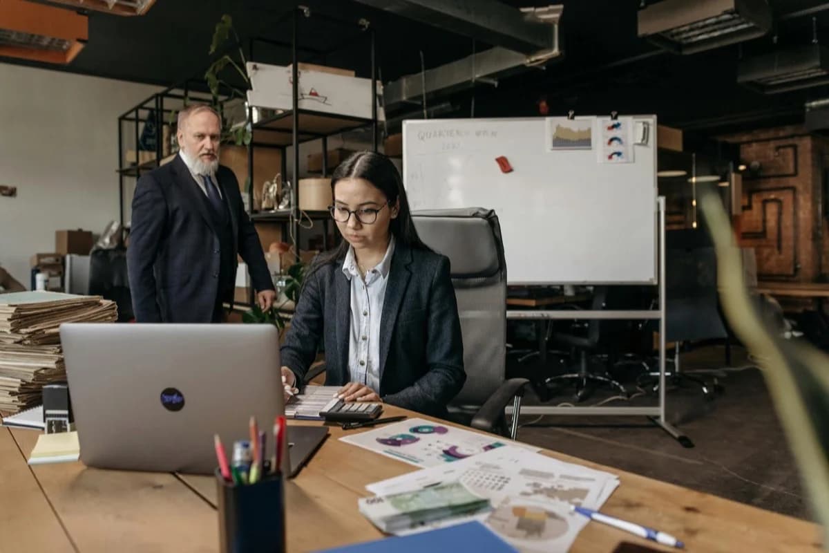 Professionisti collaborano in ufficio moderno con laptop e tablet