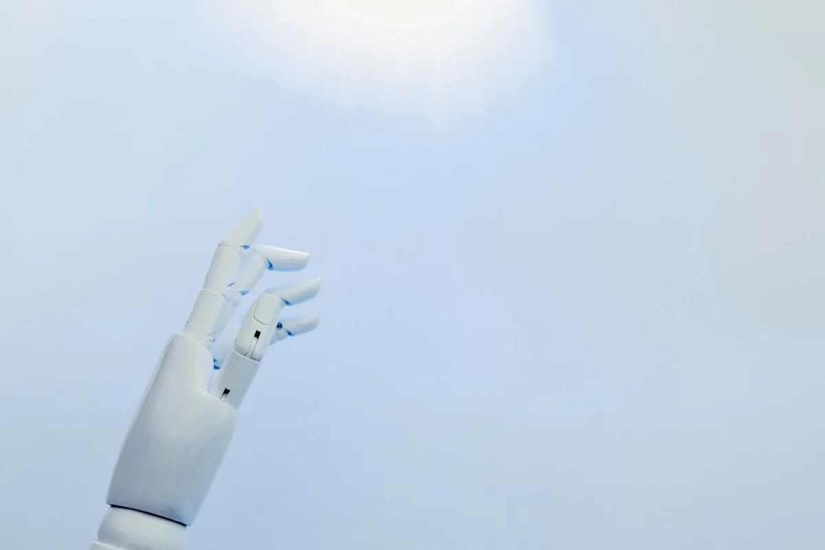 Mano robotica tecnologica verso luce brillante, simbolo automazione AI futuristica